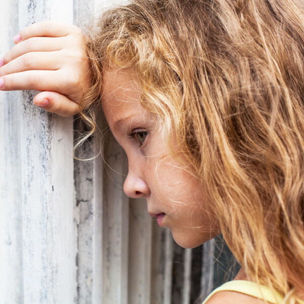 Nachdenkliches Mädchen lehnt mit dem Kopf an der Wand
