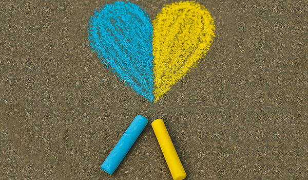 Blaue und gelbe Straßenkreide unter einem gemalten Herzen