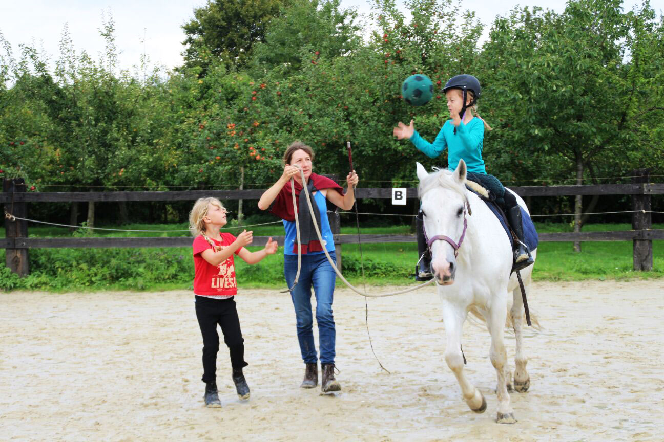 Kind reitet auf Pferd - begleitet von Brigitte Berkhoff und einem anderen Kind