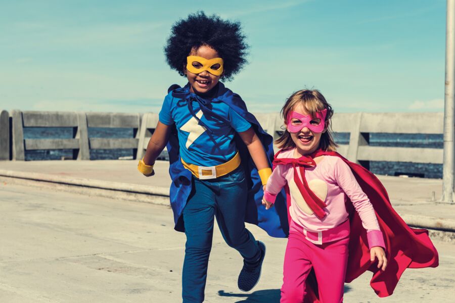 Bild von lachenden Kindern in Helden-Verkleidung mit Cape und Augenmaske
